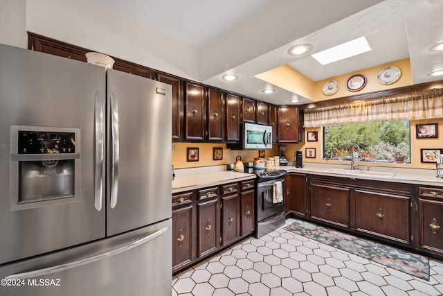 kitchen with dark brown cabinets, appliances with stainless steel finishes, light countertops, and a sink