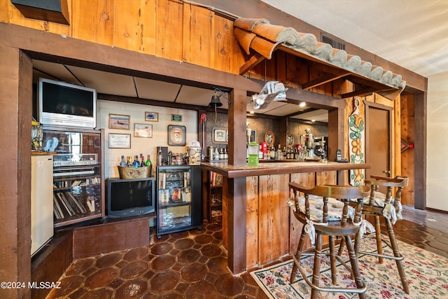 bar featuring a bar, beverage cooler, and visible vents