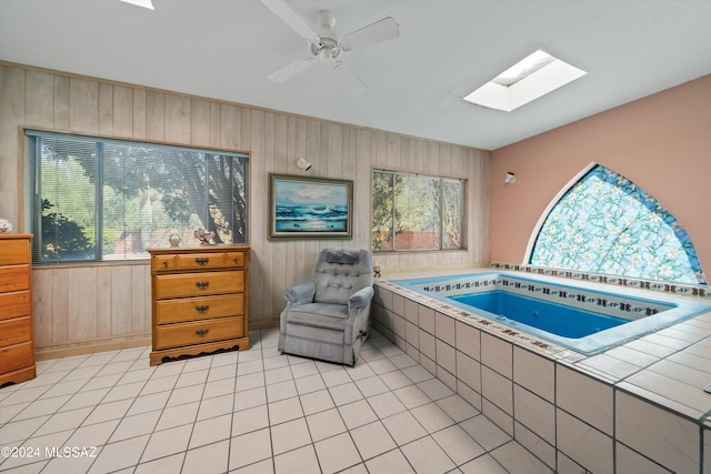 view of pool featuring a skylight and a hot tub