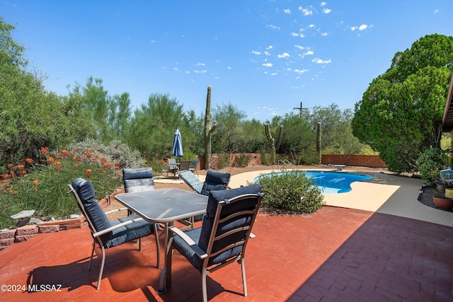 view of patio / terrace featuring a fenced in pool, outdoor dining space, and fence