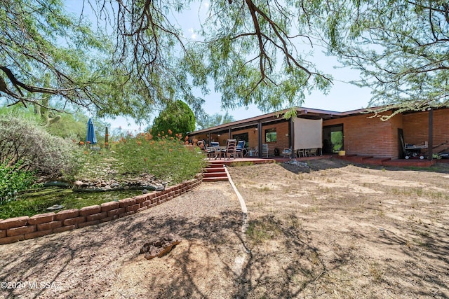 back of property featuring brick siding