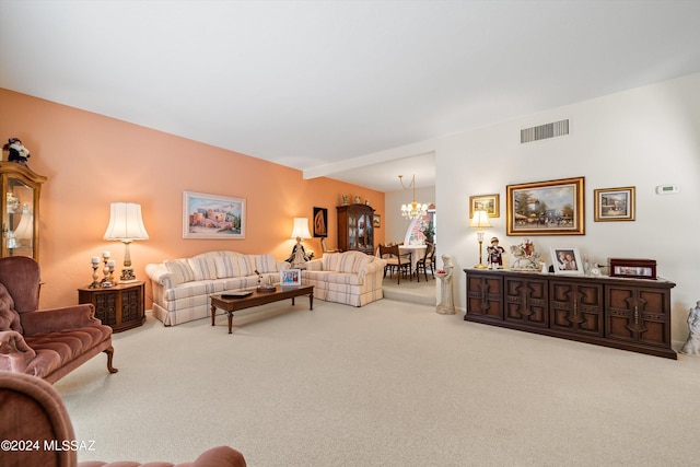 living room featuring an inviting chandelier, carpet, and visible vents