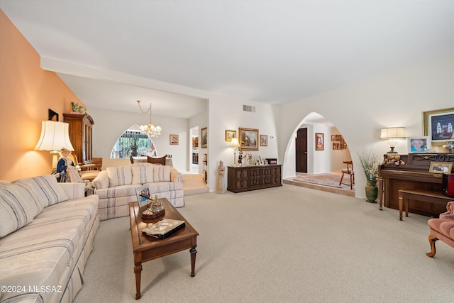 living room with light colored carpet, arched walkways, visible vents, and a notable chandelier