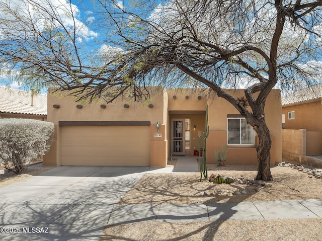 southwest-style home featuring stucco siding, driveway, and a garage