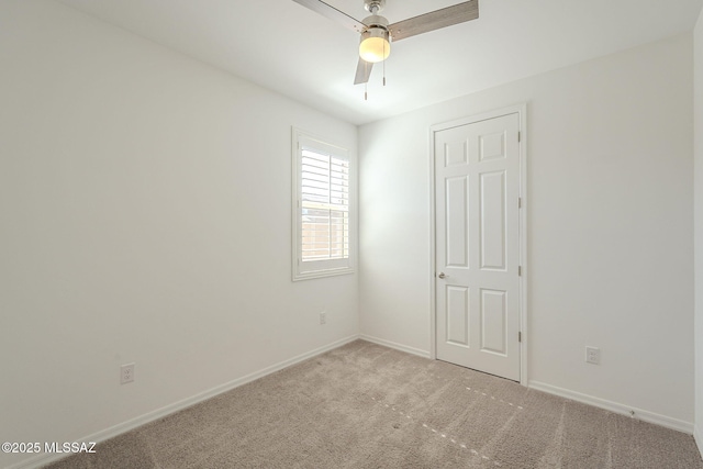 empty room featuring light carpet, baseboards, and a ceiling fan