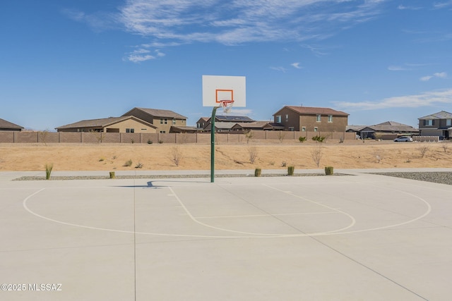 view of sport court featuring community basketball court, fence, and a residential view