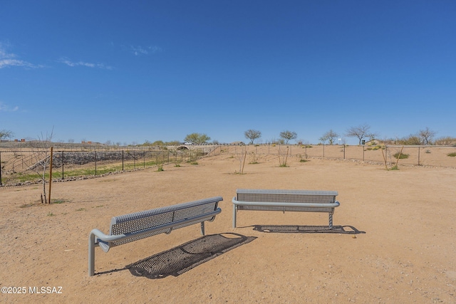 view of property's community featuring a rural view and fence