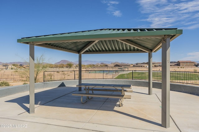 view of property's community with fence, a mountain view, and a gazebo