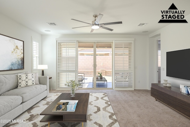 carpeted living area with visible vents and ceiling fan