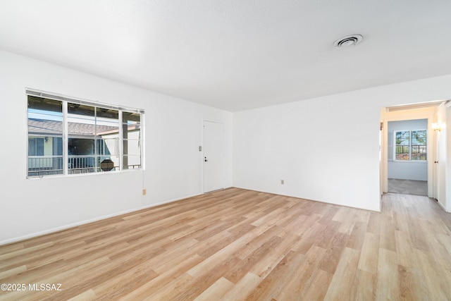 spare room with light wood finished floors and visible vents