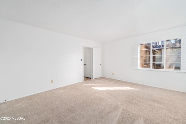 spare room featuring light colored carpet