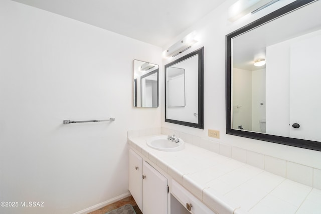 bathroom with vanity and baseboards