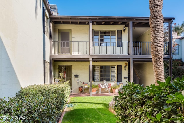 rear view of house with a balcony and a patio