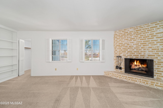 unfurnished living room with carpet floors and a brick fireplace