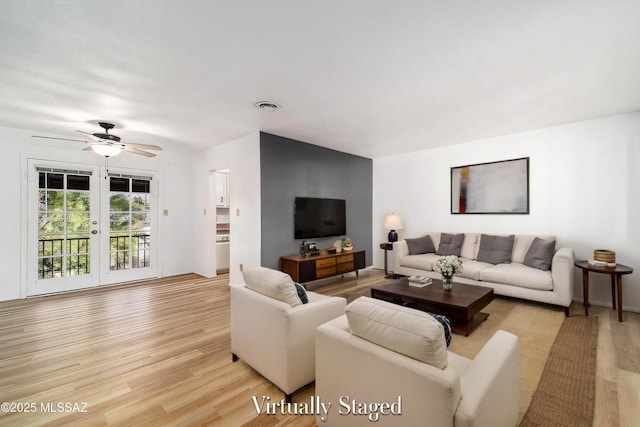 living area with french doors, light wood-type flooring, visible vents, and a ceiling fan