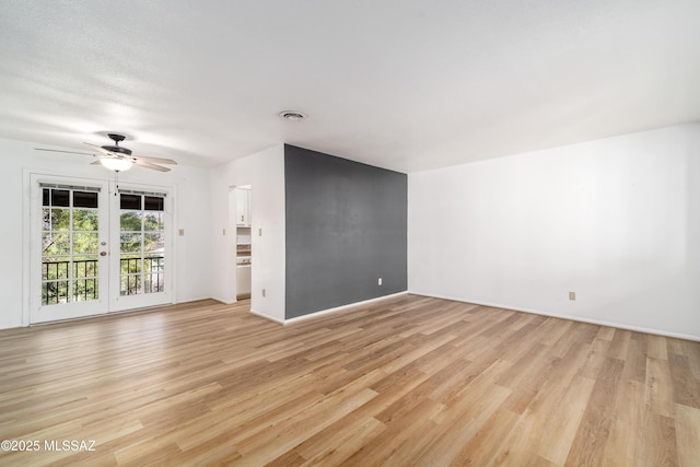 unfurnished living room with french doors, light wood-type flooring, visible vents, and a ceiling fan