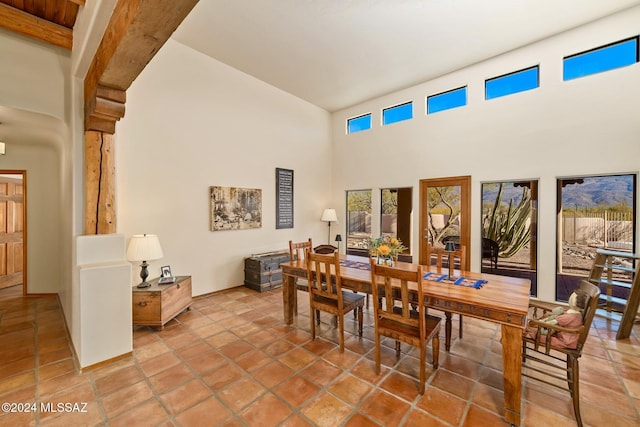 dining area featuring a towering ceiling and light tile patterned floors