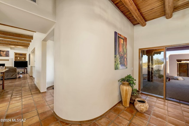 corridor featuring tile patterned flooring, wooden ceiling, and beamed ceiling