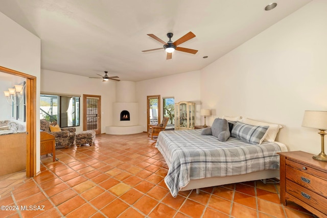 bedroom featuring access to outside, multiple windows, a fireplace, and light tile patterned floors