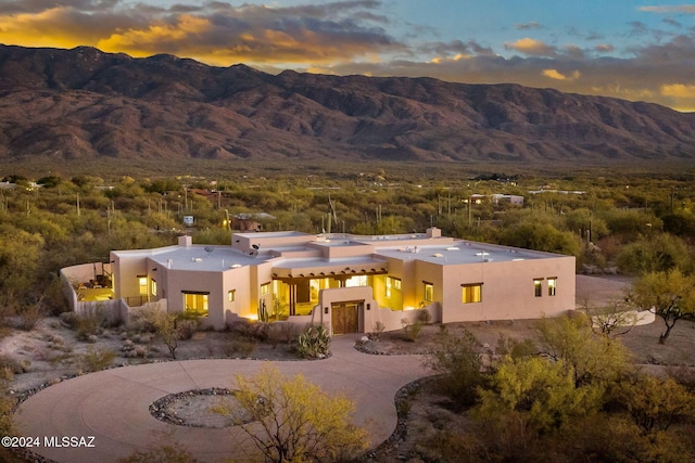 exterior space with a chimney, a mountain view, and stucco siding