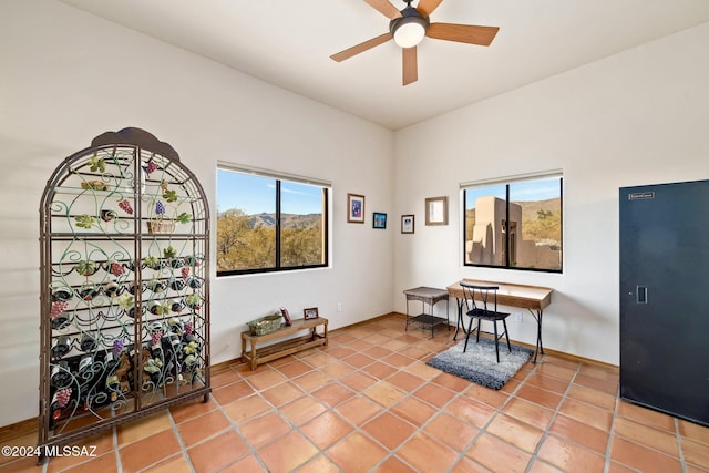 tiled office with a ceiling fan and baseboards