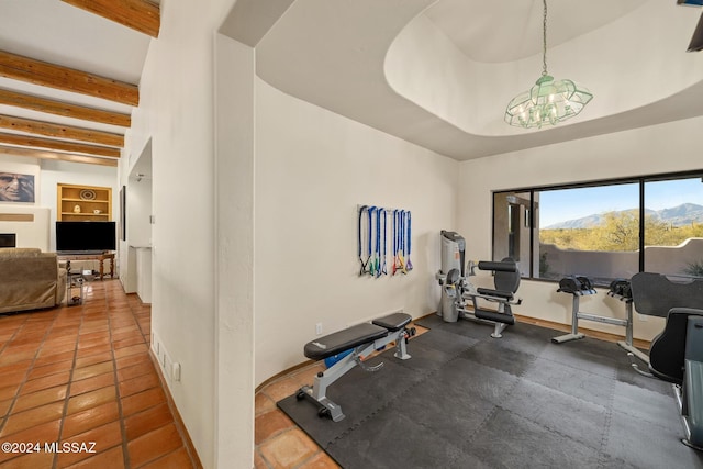 exercise area featuring built in features, a fireplace, and baseboards