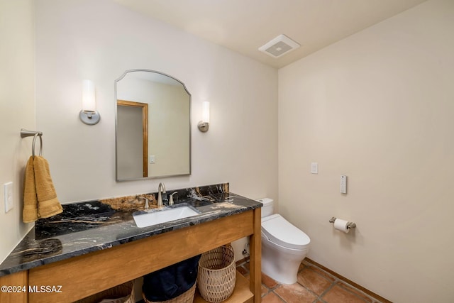 half bath with toilet, vanity, visible vents, and tile patterned floors