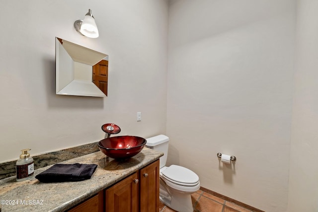 bathroom with toilet, tile patterned floors, and vanity