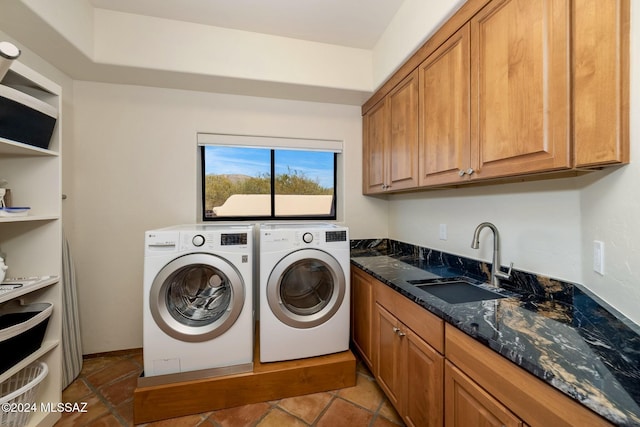 washroom featuring cabinet space, washer and clothes dryer, and a sink