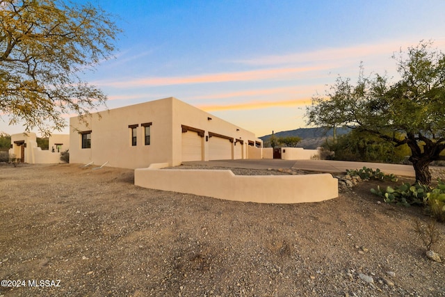 back of house with an attached garage and stucco siding