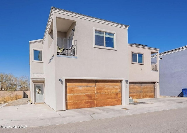 125 E Stone Ct, Tucson, AZ 85705 - rear view of property with stucco siding, a garage, and a balcony