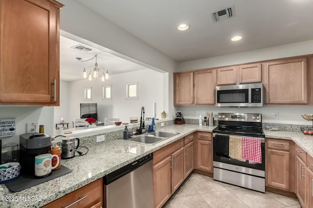 kitchen featuring light tile patterned floors, visible vents, appliances with stainless steel finishes, hanging light fixtures, and a sink