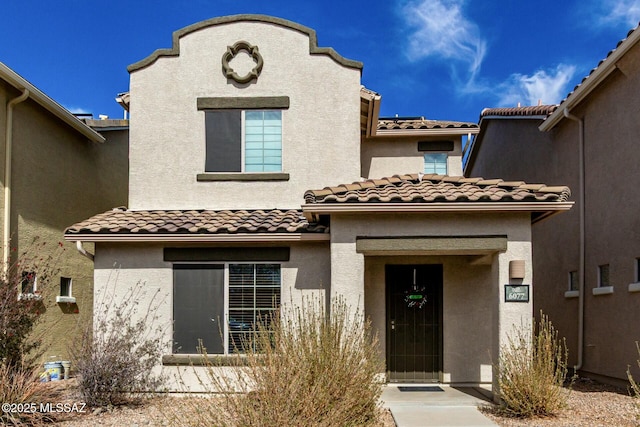 view of front of house with a tile roof and stucco siding