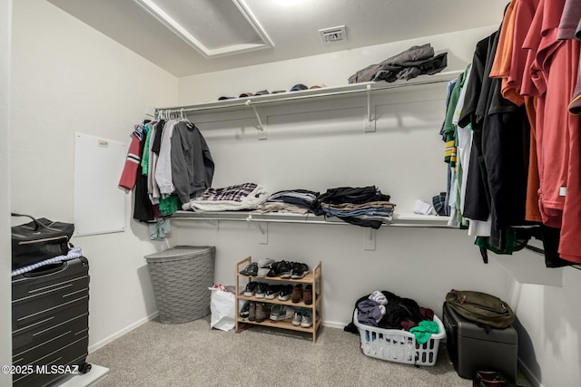 spacious closet featuring attic access, visible vents, and carpet flooring