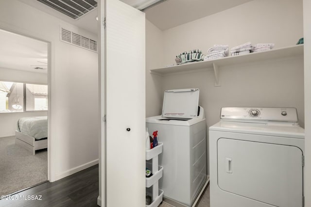 laundry room with laundry area, baseboards, visible vents, dark wood-type flooring, and separate washer and dryer