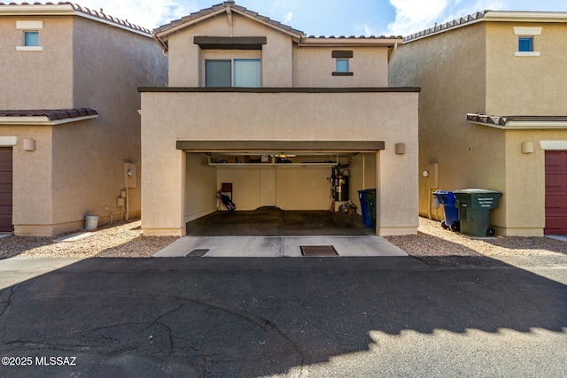 view of front of property with a garage, a tiled roof, aphalt driveway, and stucco siding