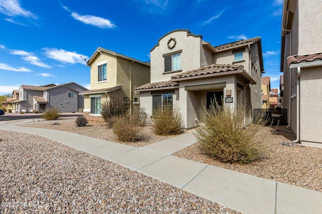 view of front of house featuring a residential view, a tile roof, fence, and stucco siding