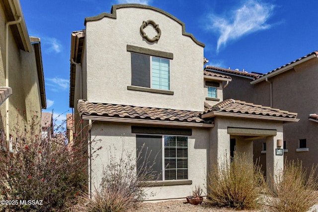 mediterranean / spanish-style home featuring a tile roof and stucco siding