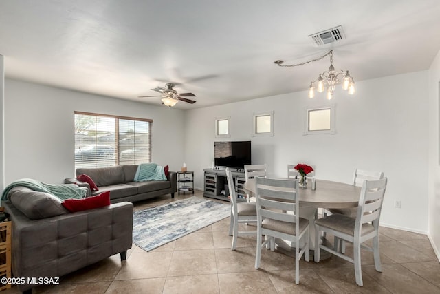 living room featuring ceiling fan with notable chandelier, light tile patterned flooring, visible vents, and baseboards