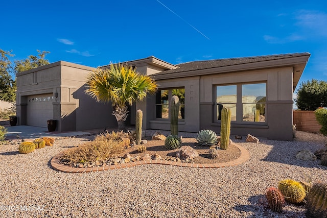 view of front of house with an attached garage and stucco siding