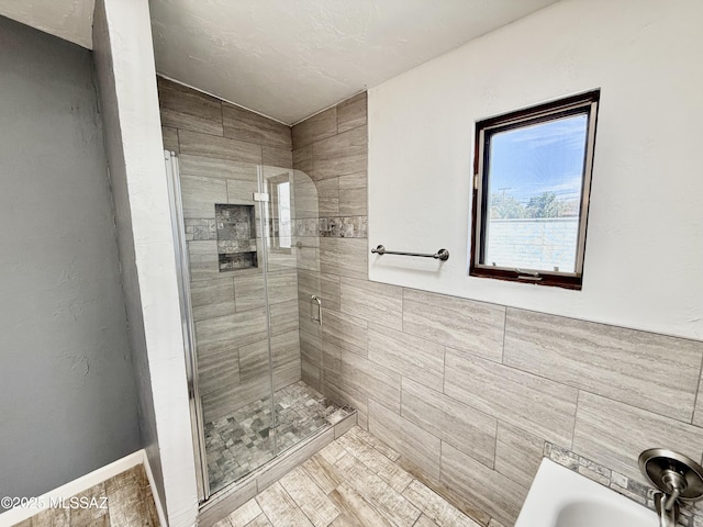 full bath with a tub, a shower stall, and tile walls