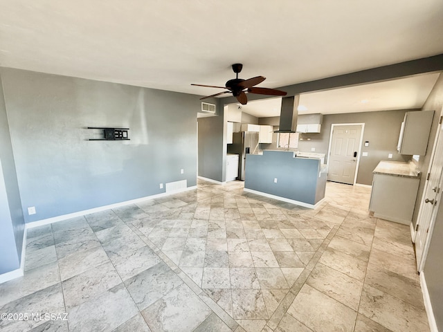 kitchen featuring a ceiling fan, light countertops, visible vents, and baseboards