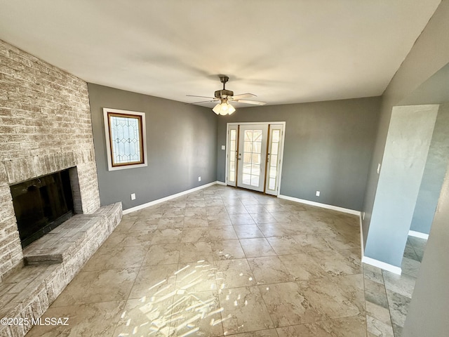 unfurnished living room featuring ceiling fan, a fireplace, and baseboards