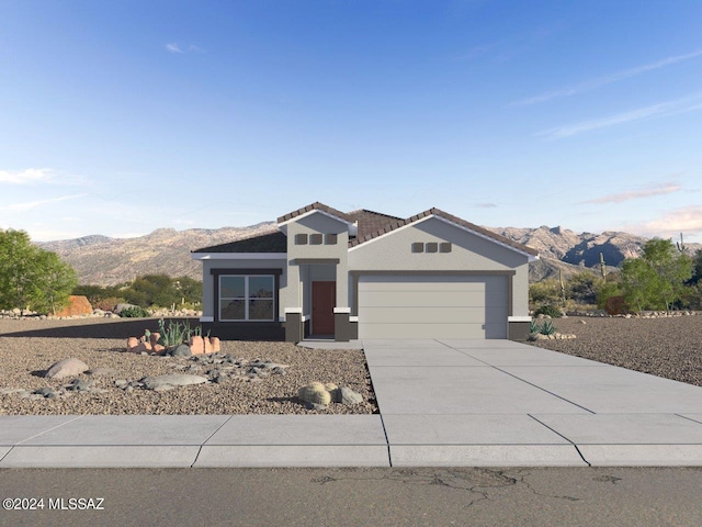 view of front of house featuring driveway, an attached garage, a mountain view, and stucco siding