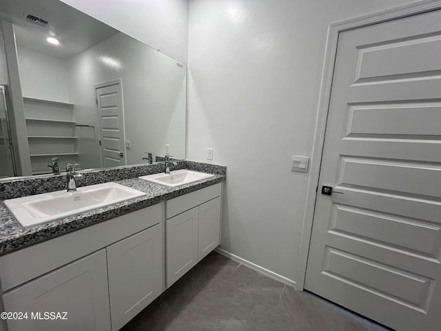 bathroom featuring visible vents, a sink, baseboards, and double vanity