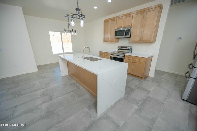 kitchen with recessed lighting, appliances with stainless steel finishes, a sink, light stone countertops, and baseboards