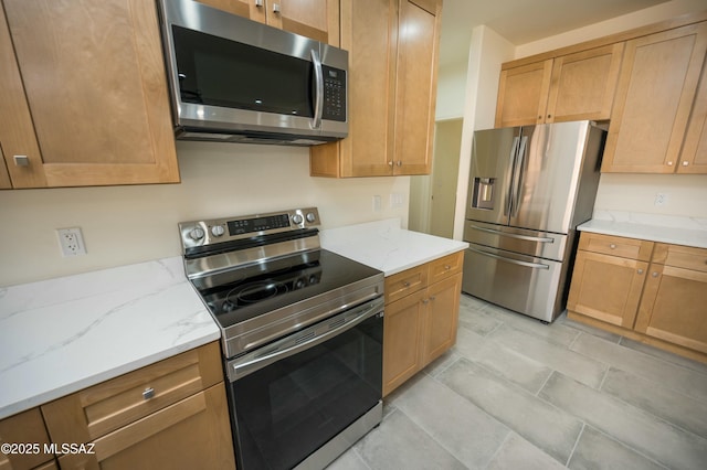 kitchen with stainless steel appliances and light stone countertops