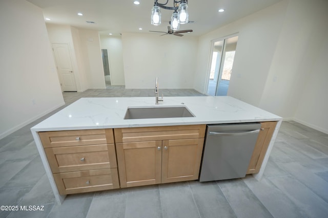 kitchen featuring open floor plan, light stone countertops, stainless steel dishwasher, pendant lighting, and a sink