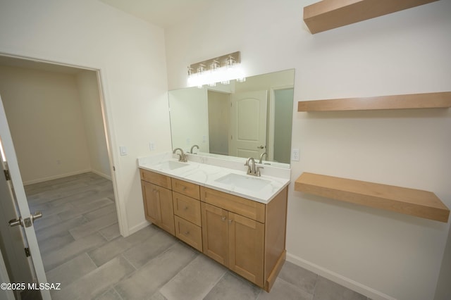 bathroom with double vanity, a sink, and baseboards