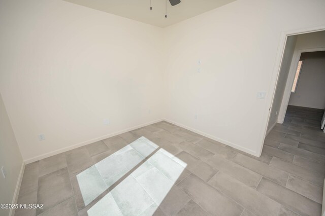 spare room featuring baseboards, visible vents, and ceiling fan